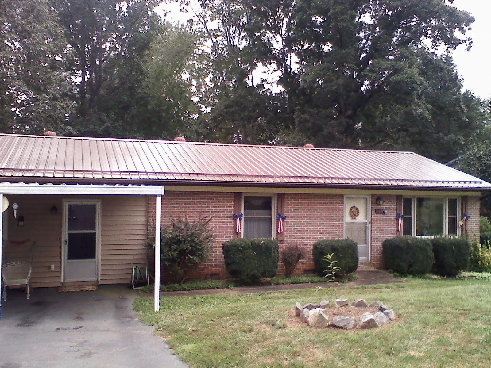 Bronze metal roof and carport on a brick ranch home — Roof Repair work by our crew in Anchorage