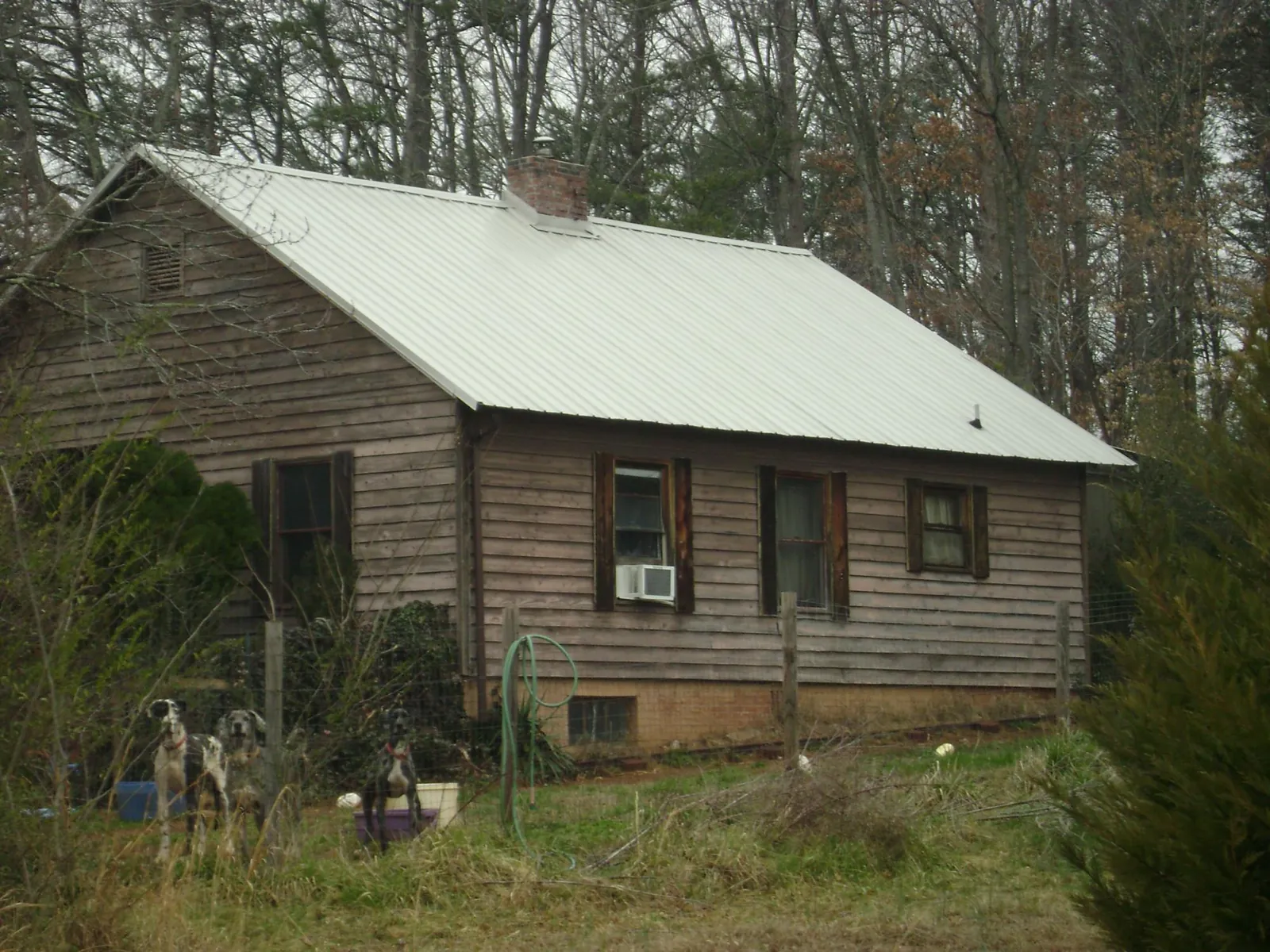 White metal roof on an old wood sided farmhouse, from a Metal Roof Installation job in Anchorage